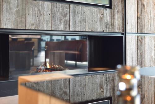 a fire pit in a restaurant with a wooden wall at R hotel experiences in Sougné-Remouchamps