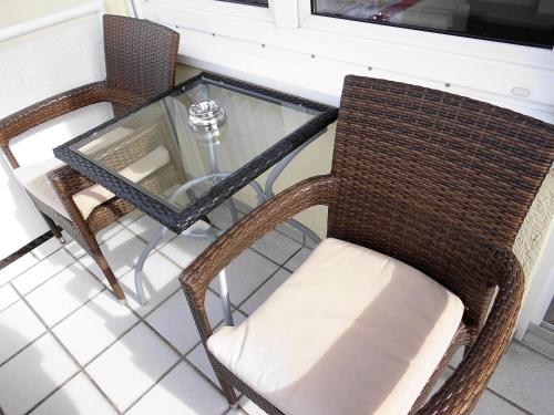 a glass table and two chairs and a glass table with a glass table and chairs at Ferienwohnung Schwalbennest in Kronau