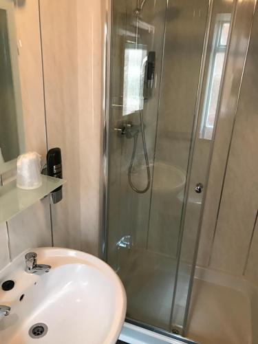 a bathroom with a shower and a sink at Queens Plaza Hotel in Blackpool