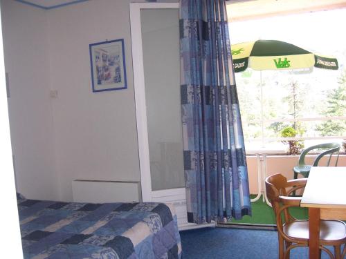 une chambre avec un lit, une table et une fenêtre dans l'établissement Hotel Saint Jacques, à Vals-les-Bains