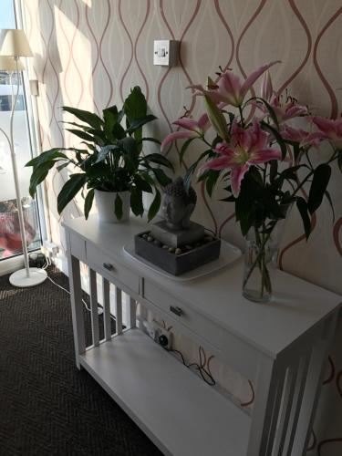a white table with flowers on top of it at Queens Plaza Hotel in Blackpool