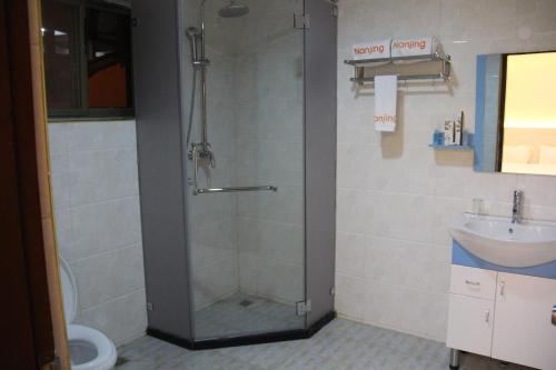 a bathroom with a shower and a sink at Nanjing Restaurant & Motel in Kampala