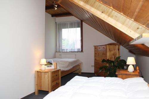 a bedroom with a white bed and a window at Haus Schwalbennest in Undeloh