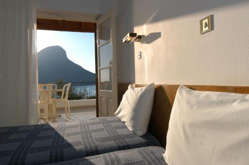 a bedroom with a bed with a view of the ocean at Oasis Hotel in Masouri