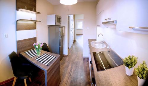 una pequeña cocina con fregadero y mesa en Apartament Fryderyk Premium 2, en Nysa