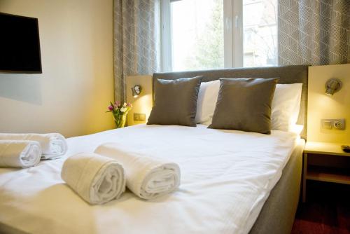 sypialnia z białym łóżkiem i ręcznikami w obiekcie Apartament Fryderyk Premium 2 w Nysie