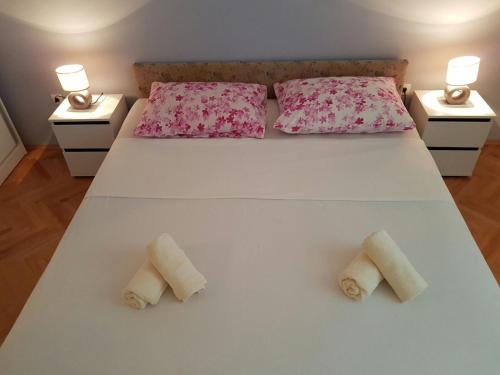 a bedroom with a large white bed with two pillows at Apartment Vice mali in Split
