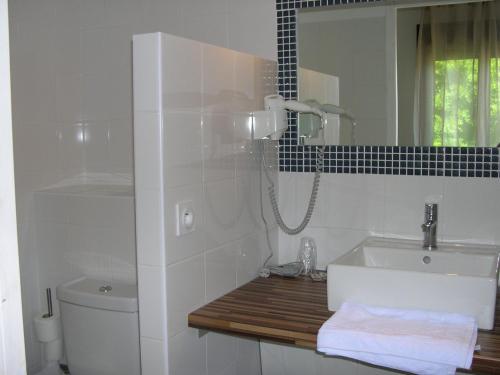 y baño con lavabo, aseo y espejo. en Hotel Costa Verde, en Moriani Plage