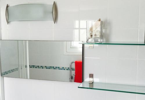 a bathroom with a mirror and a red chair at Ikaria Village Studio in Paphos