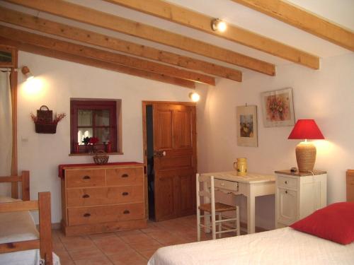 une chambre avec un lit, une table et un bureau dans l'établissement Gîte Saint-Veredeme, à Pujaut