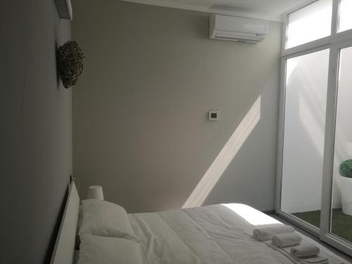 a white bedroom with a bed and a window at Lingotto Residence in Turin