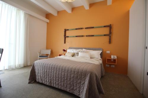 a bedroom with a large bed with orange walls at Hotel Intorno Al Fico in Fiumicino