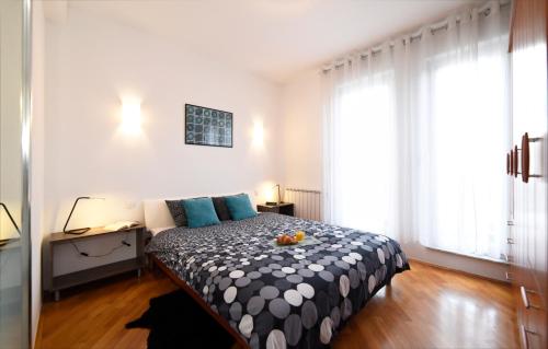 a bedroom with a bed with a black and white blanket at Corner Apartment in Zagreb