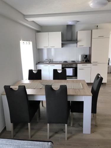 a kitchen with a wooden table and chairs at Ferienwohnungen Tannenhof in Steinen