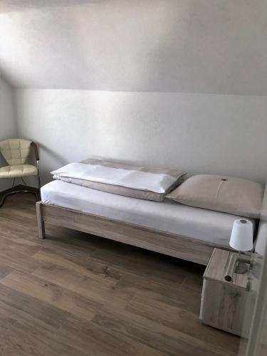 a bedroom with a bed and a chair and a table at Ferienwohnungen Tannenhof in Steinen