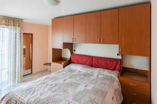 アルバ・アドリアティカにあるPalazzo Gialloのベッドルーム(大型ベッド1台、木製キャビネット付)