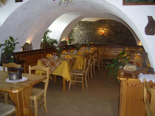 een restaurant met tafels en stoelen en een stenen muur bij Agriturismo Lo Ratelé in Allein