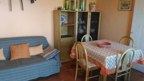 uma sala de estar com uma mesa e um sofá azul em Casa dell'Oleandro em Torre Faro