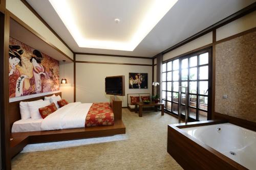a bedroom with a bed and a tub and a television at Ramada by Wyndham Podgorica in Podgorica