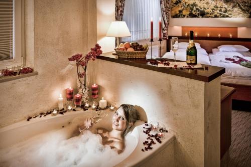 a woman laying in a bath tub in a hotel room at Appartements Lüftenegger in Mauterndorf