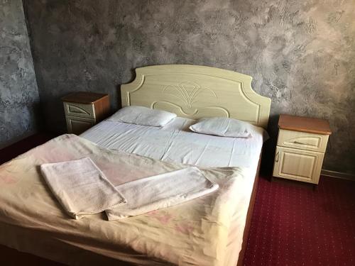 a bedroom with a white bed with two night stands at Power House Hotel in Lutsk