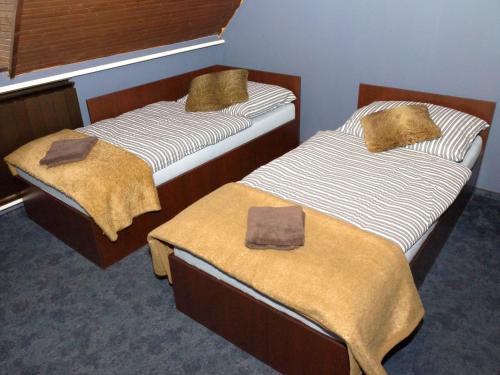 Dos camas en una habitación con toallas. en Ipoly Party-Ház, en Balassagyarmat