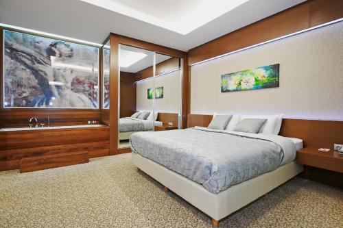 a bedroom with a large bed and a sink at Ramada by Wyndham Podgorica in Podgorica