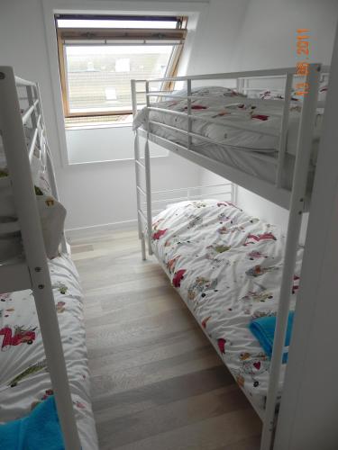 a bunk room with two bunk beds and a window at Appartement 3 Chambres A Koksijde in Koksijde