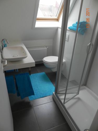 a bathroom with a toilet and a sink and a window at Appartement 3 Chambres A Koksijde in Koksijde