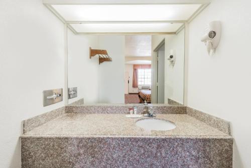 a bathroom with a sink and a mirror at Americas Best Value Inn & Suites Fort Worth South in Fort Worth