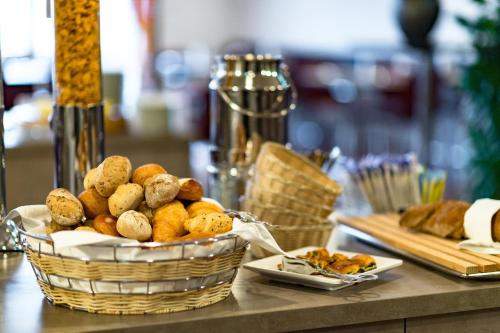 a basket of bread and pastries on a table at Hotel Sternen Oerlikon in Zürich