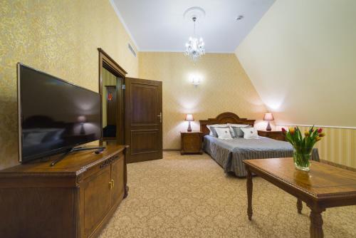 a hotel room with a bed and a flat screen tv at Hotel Jarosław in Jarosław
