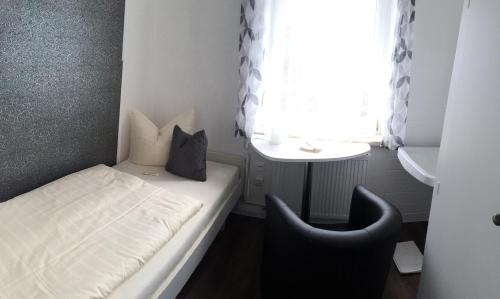 a small room with a bed and a chair at Hotel Sonnenklause in Travemünde