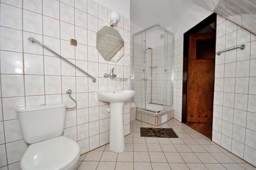 ザコパネにあるPokoje pod Gubałówkąのトイレと洗面台を備えた白いバスルーム