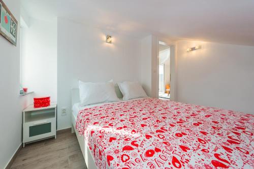 1 Schlafzimmer mit einem Bett mit einer roten Blumenbettdecke in der Unterkunft Apartment Marita in Zaboric