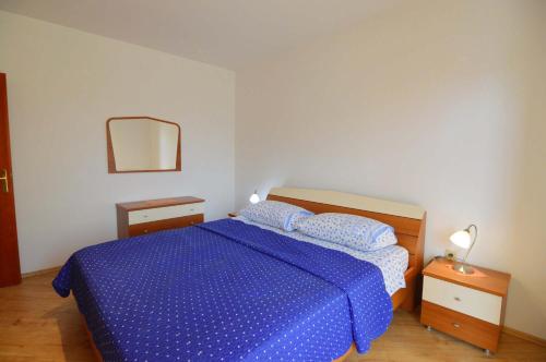 a bedroom with a bed with a blue comforter at Garden Apartment Maria in Vrsar