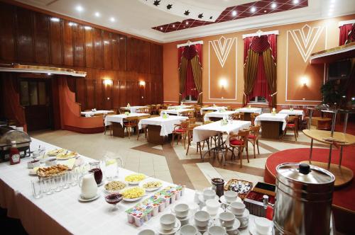 ein Restaurant mit Tischen und Platten. in der Unterkunft Oktyabrskaya in Pskow