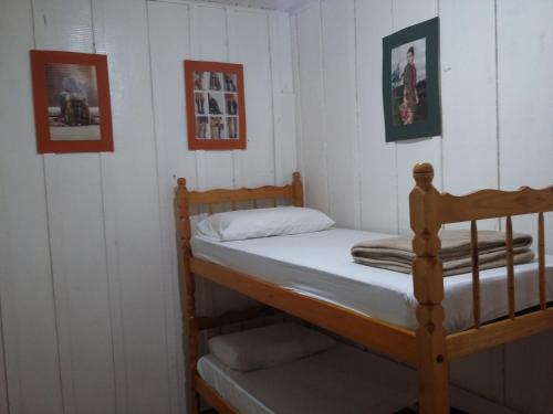 a bedroom with a bunk bed and two pictures on the wall at IguassuEcoHostel - Eco Suítes - Hostel mais próximo das Cataratas in Foz do Iguaçu