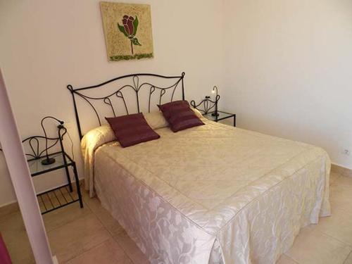 ein Schlafzimmer mit einem Bett mit zwei Kissen darauf in der Unterkunft Casitasmanoli Conil in Conil de la Frontera