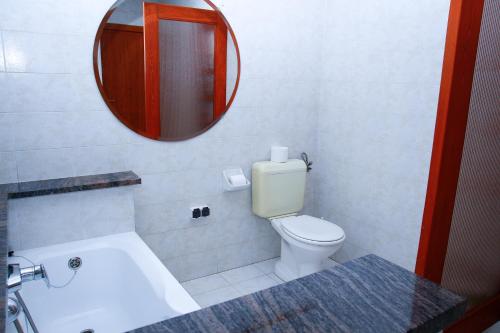a bathroom with a white toilet and a mirror at Princess Apartman in Siófok
