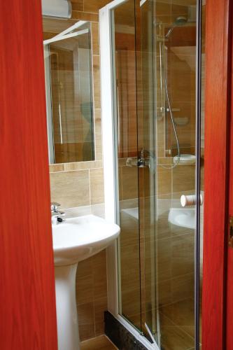 a bathroom with a sink and a glass shower at Princess Apartman in Siófok