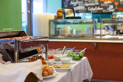 a buffet line with plates of food in a restaurant at Cityhome Downtown Suites & Spa in Budapest