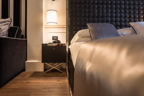 a bedroom with two beds and a table with a lamp at Verona House Aparthotel in Verona