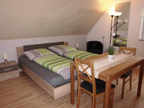 1 dormitorio con 1 cama con mesa y comedor en Ferienhaus Kiesel, en Bad Bocklet