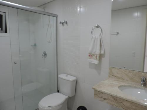 y baño con aseo, ducha y lavamanos. en Canela - 2 suítes - Vivendas do Lago, en Canela