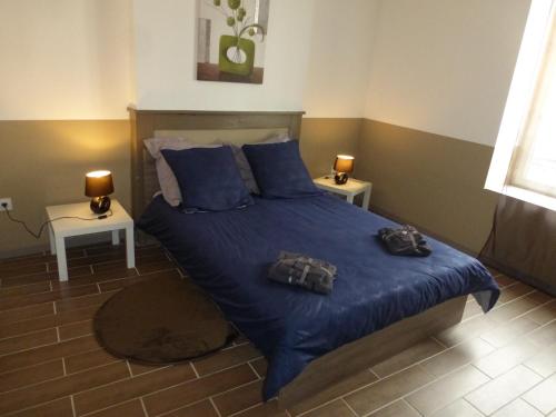 une chambre avec un lit avec des draps et des oreillers bleus dans l'établissement Au Vélo Fleuri, à Bracieux