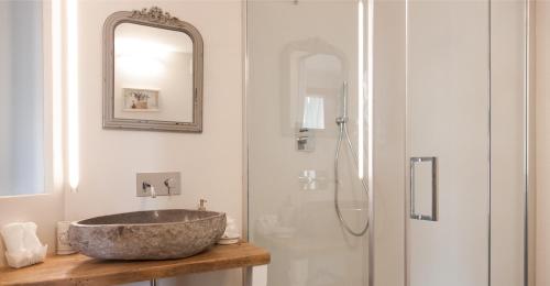 a bathroom with a stone sink and a shower at La Pulcia B&B in Gradara
