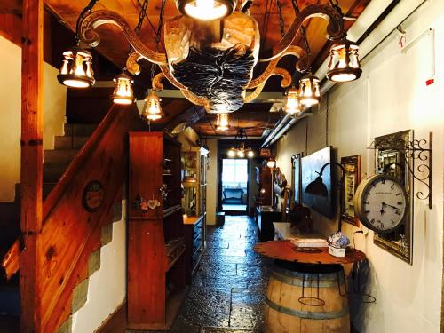 a hallway in a pub with a clock on the wall at Auberge de l'Assesseur - Mont-Soleil in Saint-Imier