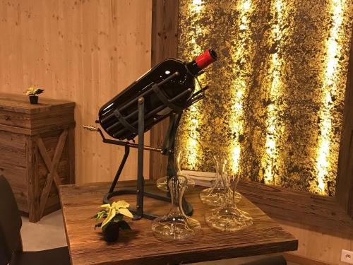 a bottle of wine on a stand next to two wine glasses at Hotel Terminus in Küblis