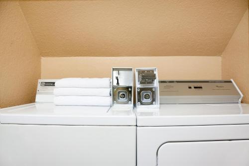 a washer and dryer with two speakers and towels at Super 8 by Wyndham Tuscola in Tuscola
